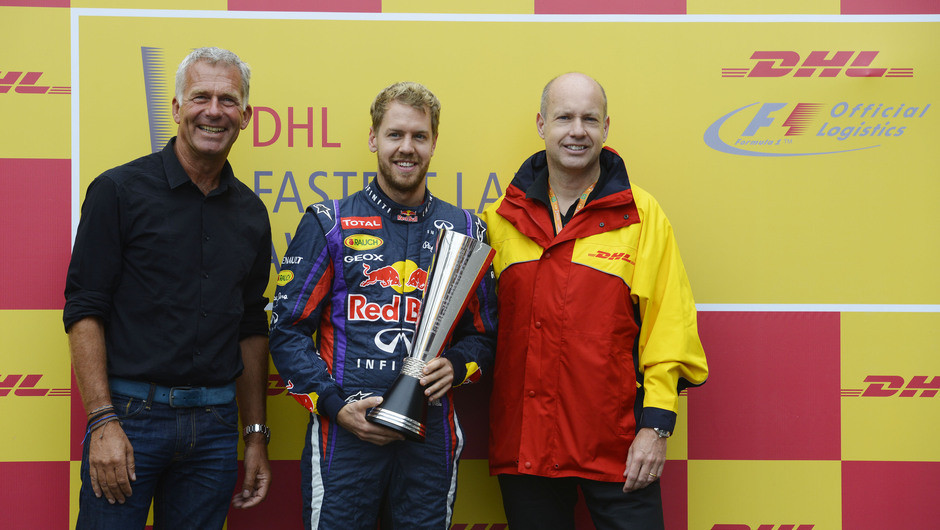 Former Formula 1™ racing driver Christian Danner (left) and DHL Express Brazil Managing Director Joakim Thrane (right) present the DHL Fastest Lap Award 2013 to Sebastian Vettel.